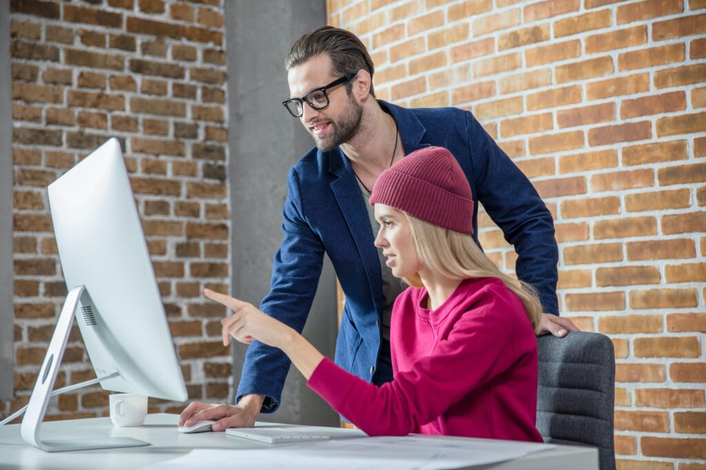 Young stylish man and woman working on computer in office